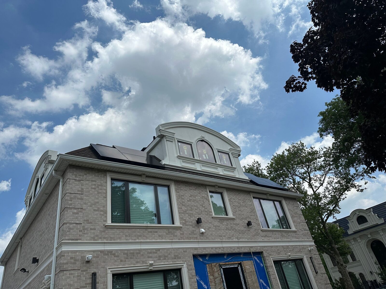 Solar on a brick-front New York home under a clear sky